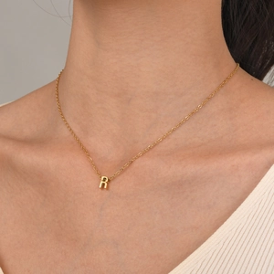 Elegant gold titanium steel necklace featuring a polished 3D letter R alphabet pendant