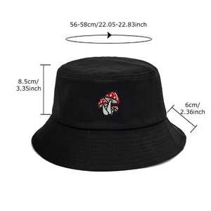 Black cotton bucket hat featuring red mushroom embroidery seen from a 45-degree angle