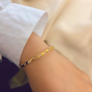 Elegant gold titanium steel bangle with inlaid zircons worn with a white shirt