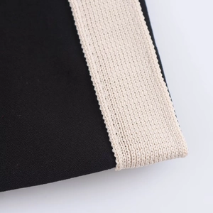 Close-up of black fabric texture with off-white elastic waistband detail for set