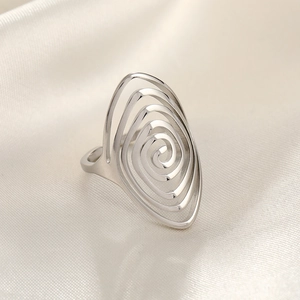 Detailed view of silver hammered ring with hollow spiral design on cream silk fabric