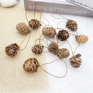 Macro shot of natural pine cone ornaments with rustic hanging loops on soft textures