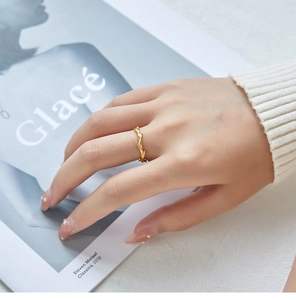 Detail of 18K gold plated honeycomb ring worn on finger with chic magazine background