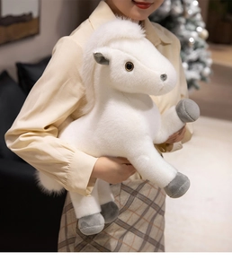 Detail eines weichen weißen Plüschponys mit flauschiger Mähne, im Arm gehalten