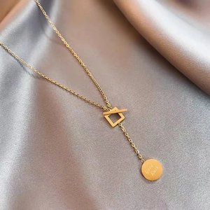 Detail of gold titanium necklace with T-bar clasp and Good Luck pendant on silk