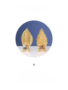 Close-up of golden metal leaf sculpture with a transparent crystal sphere base decor