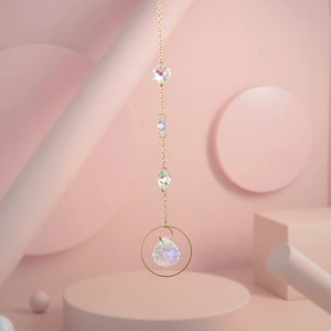 Macro detail of iridescent teardrop crystal pendant on gold metal ring with light prisms