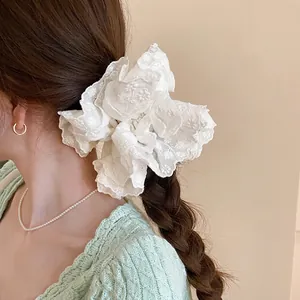 Elegant white double-layered lace scrunchie with floral embroidery shown on a ponytail