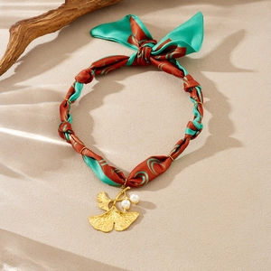Detail of floral print silk ribbon necklace with gold ginkgo leaf and pearl pendant