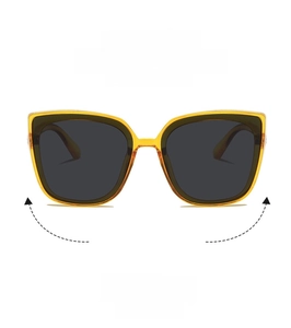 Close-up of oversized amber cat-eye sunglasses with gradient lenses and metal hinges
