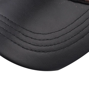 Close-up of black PU leather hat brim with textured lychee grain and triple-row stitching