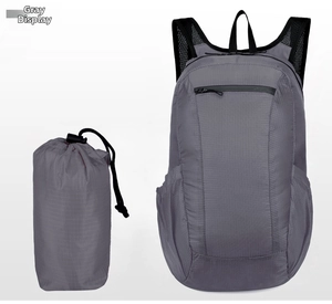 Detail view of foldable grey lightweight waterproof backpack next to its compact storage pouch