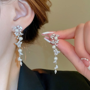 Detail of silver long tassel earrings with faux pearls and marquise zircon leaves