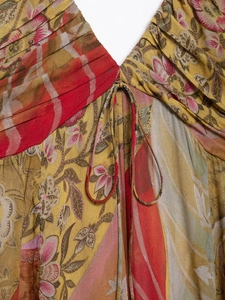 Detail of the plunging V-neckline with delicate pleats and boho print on a midi dress