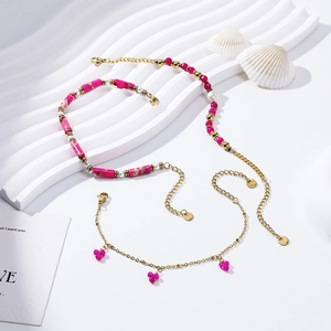 Freshwater pearl and rose red stone gold-plated stainless steel jewelry set on white stand