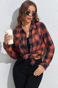 Detail of checkered flannel shirt tied at the waist with orange and navy plaid pattern
