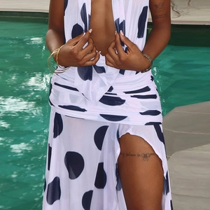 Close-up of black polka dot pattern on a white halter dress with a high slit detail