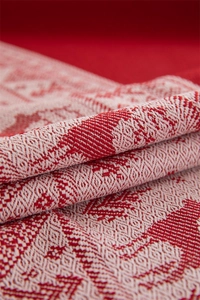 Macro shot of red and white jacquard reindeer pattern fabric with woven fringe detail