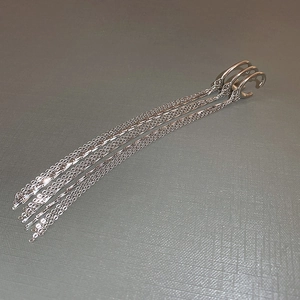 Detail showing the triple-layer silver tassel ear cuff with long metallic chain fringe