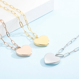 Trois colliers avec pendentifs en forme de cœur en or, argent et rose gold et maillons