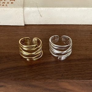 Close-up of woven sterling silver rings in gold and silver finish with S925 stamp