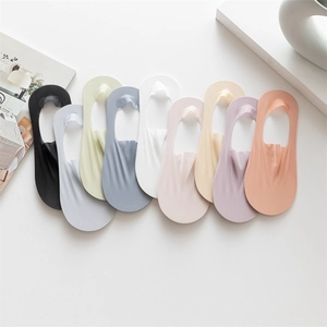 Nine pairs of colorful cotton no-show socks arranged in a gradient on a white table
