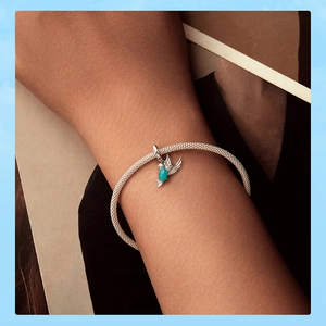 Détail d'un bracelet en maille d'argent 925 avec pendentif colibri et pierre verte