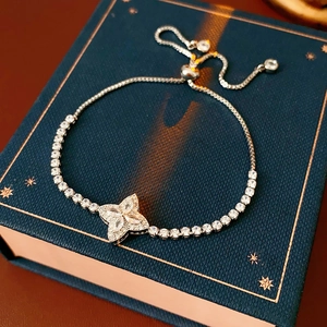 Detail of silver adjustable clover bracelet with sparkling zircons on a gift box
