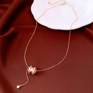 Detail of gold-plated gourd necklace featuring a red stone pendant with zircon inlay