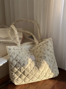 Détail du sac cabas matelassé en velours côtelé avec fleurs et étiquette en français