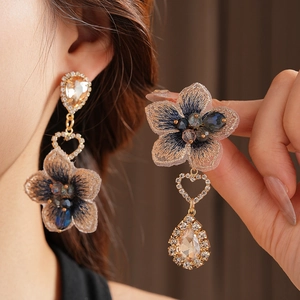 Détail de boucles d'oreilles fleurs vintage avec broderie bleu-brun et cristaux en goutte
