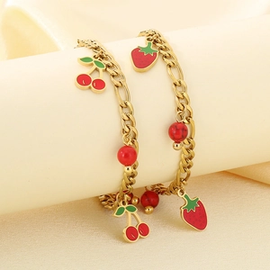Detail shot of 18K gold plated stainless steel bracelet with red cherry and strawberry charms