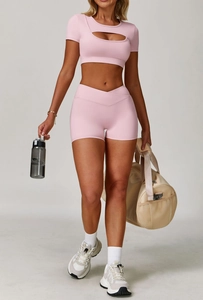 Dettaglio del set yoga rosa con top sportivo cut-out e pantaloncini a vita alta