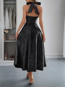 Dettaglio di elegante abito nero con scollo all'americana, lacci sulla schiena e jacquard