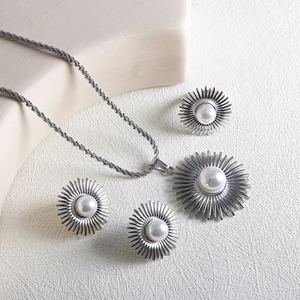 Sunflower pearl jewelry set with silver necklace earrings and ring on cream leather