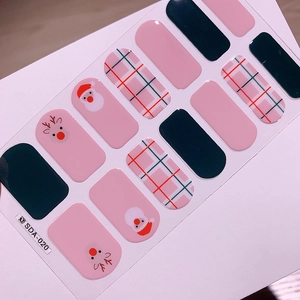 Détail de stickers à ongles de Noël avec Père Noël, renne et motifs à carreaux