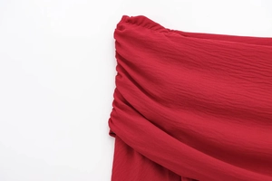 Close-up of pleated red chiffon fabric detailing soft texture and ruched craftsmanship