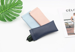 Three leather glasses pouches in blue and pink with self-closing metal spring openings