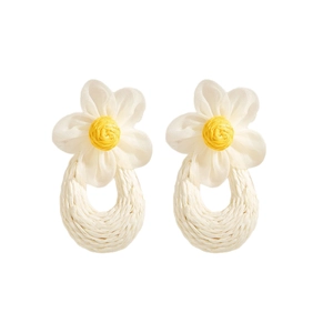 Detail of woven daisy earrings with cream fabric petals and raffia pendant