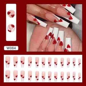 Long ballerina press-on nails with white French tips and glittery red heart designs