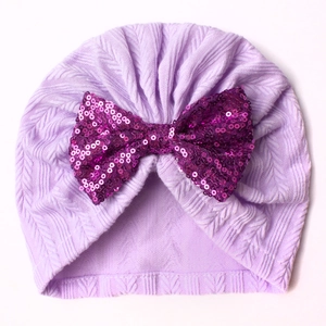 Detail of light purple baby turban hat with a large deep purple sequin bow decoration