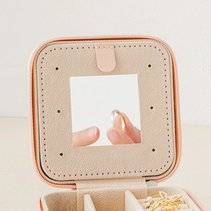 Portable peach pink jewelry box with mirror and soft velvet slots for rings and necklaces