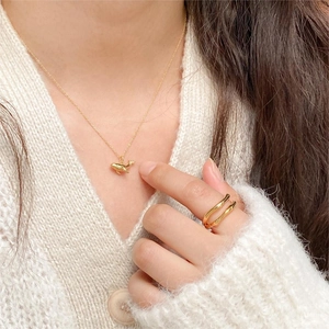 Close-up of a 925 sterling silver whale pendant necklace and ring in gold finish