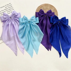 Detailed flat lay of silk satin bow hair clips in purple and blue with long streamers