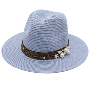 Detail of light blue straw fedora with leopard band, white pearls and floral accents