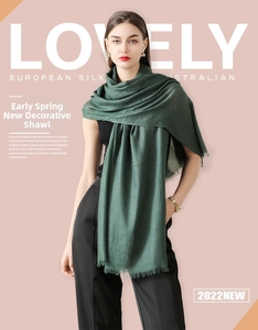 Detailed close-up of dark green silk scarf featuring delicate fringe edges and soft texture
