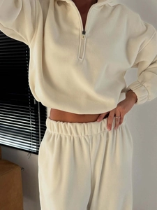 Detail of cream white fleece set featuring half-zip collar and soft textured fabric