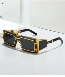 Detailed close-up of punk style square sunglasses with gold metal frame and black lenses