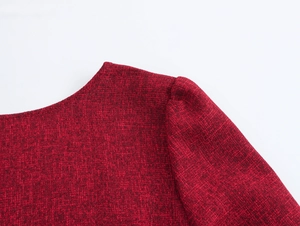 Dettaglio della trama in tweed rosso e delle cuciture sulla spalla dell'abito elegante