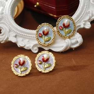 Detailed close-up of vintage floral oval earrings with white pearls and gold accents